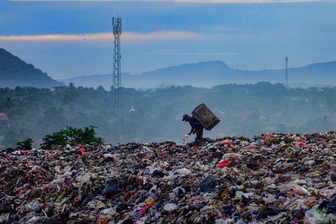Warga mengumpulkan sampah plastik dengan latar belakang  perbukitan  di TPA Galuga, Bogor, Kamis (06/22/2025). Kementerian Lingkungan Hidup meminta seluruh TPA yang masih menggunakan sistem open dumping di wilayah Jabodetabek untuk segera melakukan capping atau penutupan tumpukan sampah guna mencegah pencemaran lingkungan dan penyebaran mikroplastik.