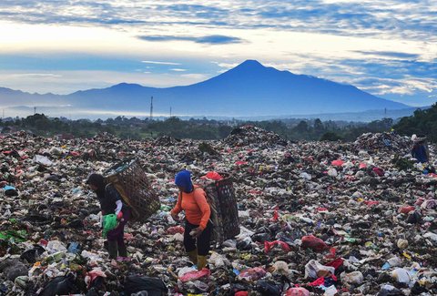 Warga mengumpulkan sampah plastik dengan latar belakang  Gunung Gede-Pangrango di TPA Galuga, Bogor, Kamis (06/22/2025). Kementerian Lingkungan Hidup meminta seluruh TPA yang masih menggunakan sistem open dumping di wilayah Jabodetabek untuk segera melakukan capping atau penutupan tumpukan sampah guna mencegah pencemaran lingkungan dan penyebaran mikroplastik.