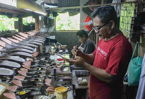 Pekerja menyelesaikan pembuatan sandal wanita di pabrik rumahan Pesan Sepatu Indonesia, Setu, Tangerang Selatan, Banten, Jumat (7/11/2025).