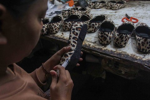 Pekerja menyelesaikan pembuatan sandal wanita di pabrik rumahan Pesan Sepatu Indonesia, Setu, Tangerang Selatan, Banten, Jumat (7/11/2025).