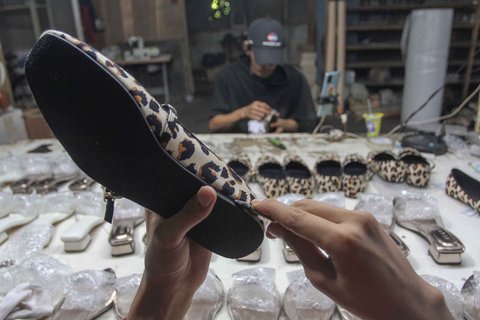 Pekerja menyelesaikan pembuatan sandal wanita di pabrik rumahan Pesan Sepatu Indonesia, Setu, Tangerang Selatan, Banten, Jumat (7/11/2025).