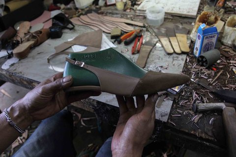Pekerja menyelesaikan pembuatan sandal wanita di pabrik rumahan Pesan Sepatu Indonesia, Setu, Tangerang Selatan, Banten, Jumat (7/11/2025).
