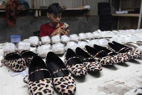 Pekerja menyelesaikan pembuatan sandal wanita di pabrik rumahan Pesan Sepatu Indonesia, Setu, Tangerang Selatan, Banten, Jumat (7/11/2025).