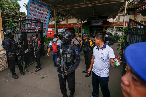 Anggota Brimob berjaga di pintu masuk pintu masuk SMAN 72 Jakarta, Jumat (07/11/2025).
