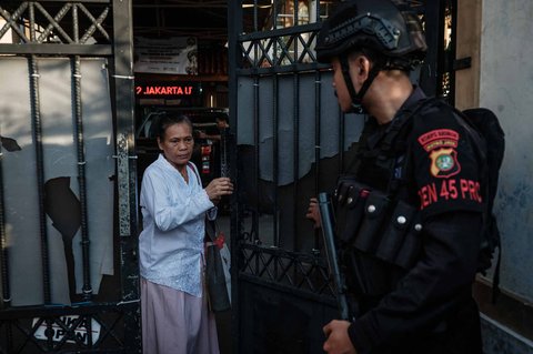 Anggota Brimob berjaga di pintu masuk pintu masuk SMAN 72 Jakarta, Jumat (07/11/2025).