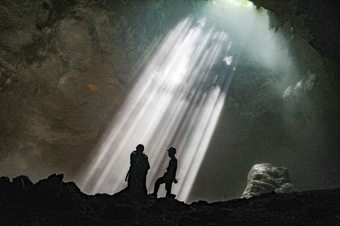 Pemandu goa memberikan penjelasan kepada wisatawan di dalam Goa Jpmblang  di Gunung Kidul, Yogyakarta.