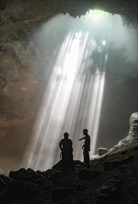 Pemandu goa memberikan penjelasan kepada wisatawan di dalam Goa Jpmblang  di Gunung Kidul, Yogyakarta.