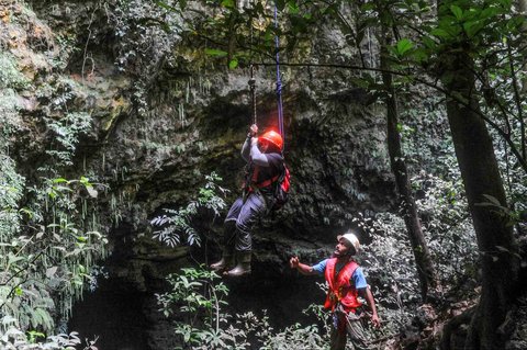 Pemandu goa mengarahkan kepada pengunjung teknik naik dengan tali usai penelusuran Goa Jpmblang  di Gunung Kidul, Yogyakarta.