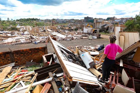 Warga berdiri di atas rumahnya yang hancur  akibat tornado dengan kecepatan angin hingga 250 km/jam yang melanda kota Rio Bonito do Iguacu, di negara bagian Parana, Brasil, Sabtu (08/11/2025) waktu setempat.