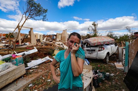 Warga berdiri di atas rumahnya yang hancur  akibat tornado dengan kecepatan angin hingga 250 km/jam yang melanda kota Rio Bonito do Iguacu, di negara bagian Parana, Brasil, Sabtu (08/11/2025) waktu setempat.