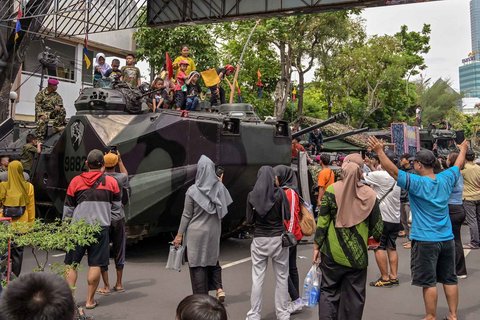 Warga berfoto dengan kendaraan militer selama Pekan Raya Marinir Indonesia di Jalan Gubernur Suryo, Surabaya, Jawa Timur, Minggu (9/11/2025).