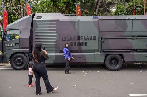 Warga berfoto dengan kendaraan militer selama Pekan Raya Marinir Indonesia di Jalan Gubernur Suryo, Surabaya, Jawa Timur, Minggu (9/11/2025).