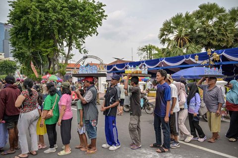 Warga antri untuk menerima bingkisan dari para marinir Indonesia dalam Pekan Raya Marinir Indonesia  di Jalan Gubernur Suryo, Surabaya, Jawa Timur, Minggu (9/11/2025).