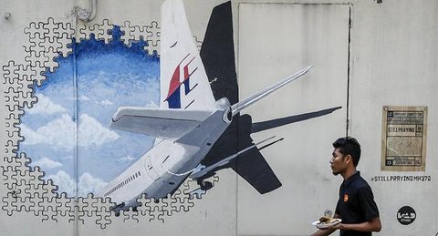 Seorang wanita menulis pesan dalam peringatan 10 tahun menghilangnya pesawat Malaysia Airlines dalam perjalanan dari Kuala Lumpur menuju Beijing, di Subang Jaya, pada tanggal 3 Maret 2024. (A