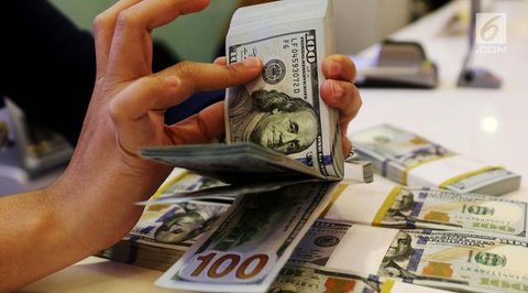 Teller menunjukkan mata uang rupiah di penukaran uang di Jakarta, Rabu (10/7/2019). Nilai tukar rupiah terhadap dolar Amerika Serikat (AS) ditutup stagnan di perdagangan pasar spot hari ini d