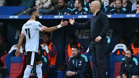 Penyerang Liverpool asal Mesir #11, Mohamed Salah (kiri), berjabat tangan dengan manajer Liverpool asal Belanda, Arne Slot (kanan), saat ia meninggalkan pertandingan, digantikan selama pertandingan Liga Primer Inggris antara Crystal Palace dan Liverpool di Selhurst Park di London selatan pada tanggal 5 Oktober 2024.(Glyn KIRK/AFP)