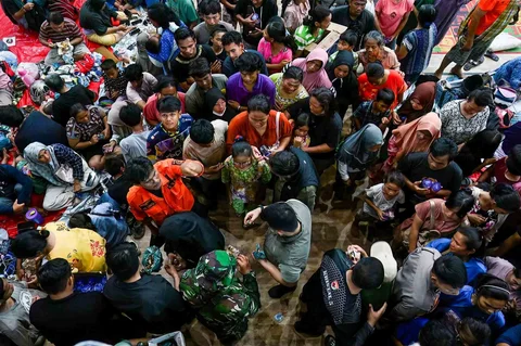 Warga antri mendapatkan makanan di tempat penampungan pascabanjir bandang dan tanah longsor di Pandan, Tapanuli Tengah, Provinsi Sumatera Utara, Indonesia, Minggu (30/11/2025).