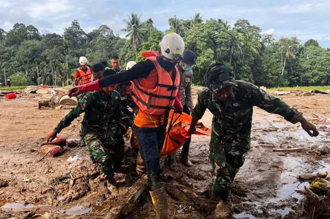 Tim penyelamat membawa jenazah korban banjir di Agam, Sumatera Barat, Indonesia, Minggu, (30/11/2025).