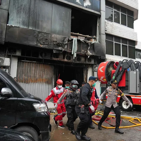 Polisi dan petugas medis mengevakuasi jenasah korban kebakaran kebakaran di gedung perkantoran Terra Drone di Jalan Letjen Suprapto, Cempaka Baru, Kemayoran, Jakarta Pusat Selasa (09/12/2025)..