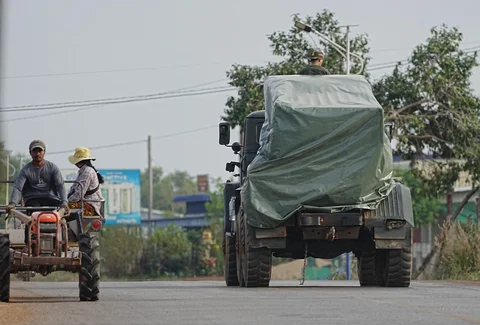 Sebuah kendaraan militer Kamboja melintas di dekat traktor milik pengungsi di Srey Snam, provinsi Siem Reap, Kamboja, Rabu (10/12/2025).