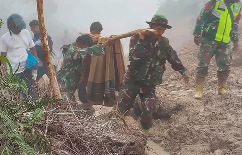 Anggota Koramil 05/Permata TNI AD mengevakuasi sepasang lansia dari wilayah terisolir menuju Puskesmas Buntul di Gucci Desa Burni Pase, Kecamatan Permata, Kabupaten Bener Meriah, Kamis (11/12/2025).
