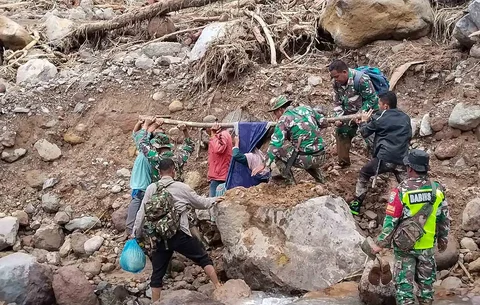 Anggota Koramil 05/Permata TNI AD mengevakuasi sepasang lansia dari wilayah terisolir menuju Puskesmas Buntul di Gucci Desa Burni Pase, Kecamatan Permata, Kabupaten Bener Meriah, Kamis (11/12/2025).