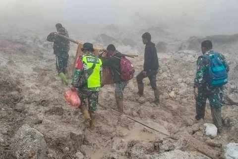 Anggota Koramil 05/Permata TNI AD mengevakuasi sepasang lansia dari wilayah terisolir menuju Puskesmas Buntul di Gucci Desa Burni Pase, Kecamatan Permata, Kabupaten Bener Meriah, Kamis (11/12/2025).
