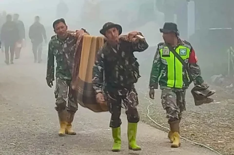 Anggota Koramil 05/Permata TNI AD mengevakuasi sepasang lansia dari wilayah terisolir menuju Puskesmas Buntul di Gucci Desa Burni Pase, Kecamatan Permata, Kabupaten Bener Meriah, Kamis (11/12/2025).