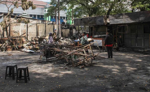 Pedagang mengamankan sisa barang yang tersisa dari warung usai dibakar sekelompok massa di Kalibata, Jakarta, Jumat (12/12/ 2025
