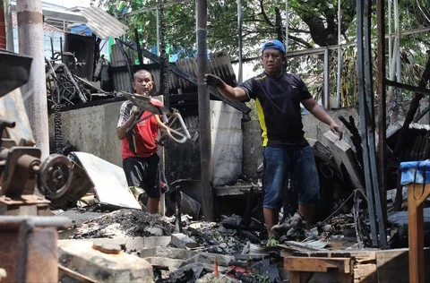 Pedagang mengamankan sisa barang yang tersisa dari warung usai dibakar sekelompok massa di Kalibata, Jakarta, Jumat (12/12/ 2025