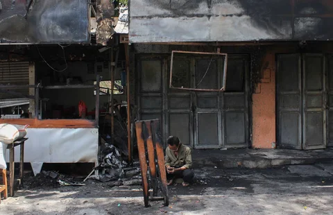 Pedagang saat mengamankan sisa barang yang tersisa dari warung usai dibakar sekelompok massa di Kalibata, Jakarta, Jumat (12/12/ 2025