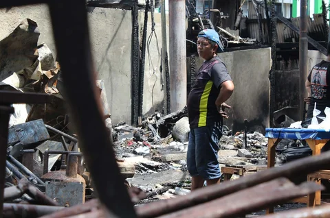 Pedagang mengamankan sisa barang yang tersisa dari warung usai dibakar sekelompok massa di Kalibata, Jakarta, Jumat (12/12/ 2025