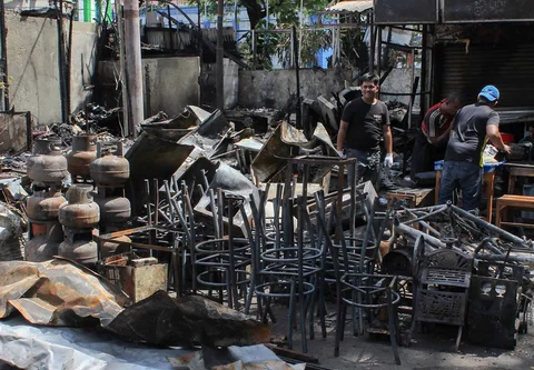 Pedagang mengamankan sisa barang yang tersisa dari warung usai dibakar sekelompok massa di Kalibata, Jakarta, Jumat (12/12/ 2025