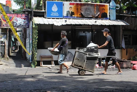 Pedagang mengamankan sisa barang yang tersisa dari warung usai dibakar sekelompok massa di Kalibata, Jakarta, Jumat (12/12/ 2025