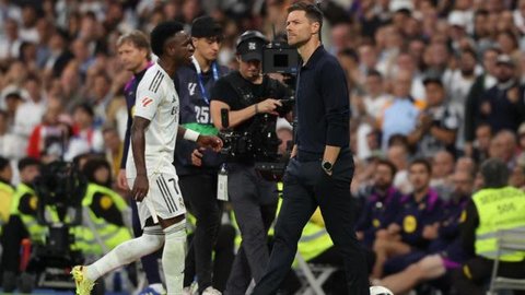 Penyerang Real Madrid asal Brasil #07, Vinicius Junior, berjalan melewati pelatih Real Madrid asal Spanyol, Xabi Alonso, saat ia digantikan dalam pertandingan Liga Spanyol antara Real Madrid CF dan FC Barcelona di Stadion Santiago Bernabeu, Madrid, pada 26 Oktober 2025. (Oscar DEL POZO/AFP)