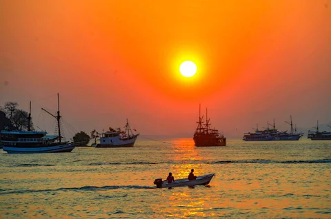 Perahu melintasi matahari terbenam di Labuan Bajo, NTT