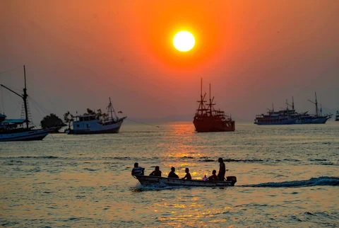 Perahu melintasi matahari terbenam di Labuan Bajo, NTT