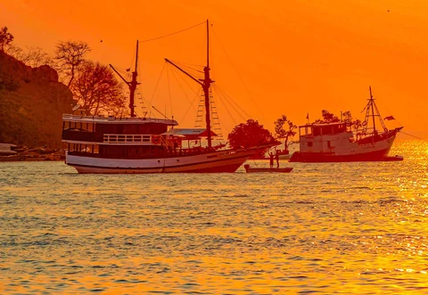 Kru kapal phinisi saat  matahari terbenam di Labuan Bajo, NTT