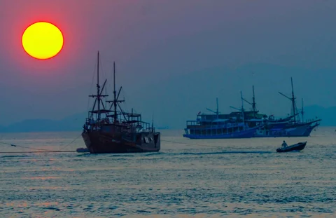 Perahu melintasi matahari terbenam di Labuan Bajo, NTT