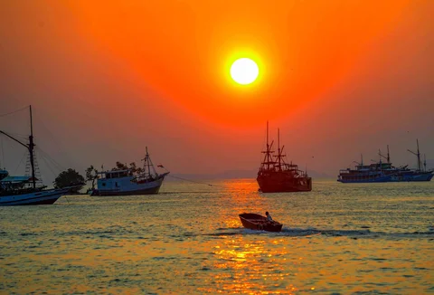 Perahu melintasi matahari terbenam di Labuan Bajo, NTT