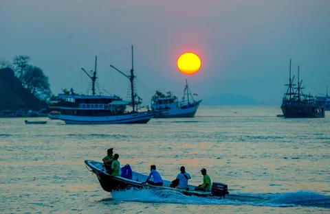 Perahu melintasi matahari terbenam di Labuan Bajo, NTT