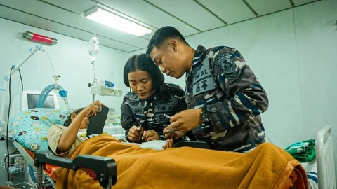 Tim medis  KRI dr. Soeharso-990 saat melakukan perawatan medis warga korban banjir bandang saat kapal lego jangkar di perairan Aceh Tamiang.Jumat (12/12/205).