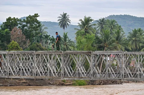 Prajurit TNI Kodam Iskandar Muda bersama petugas Kementerian Pekerjaan Umum menyelesaikan pembangunan jembatan bailey untuk memperbaiki sementara jembatan Juli yang rusak akibat bencana banjir bandang di Bireuen, Aceh, Minggu (14/12/2025),