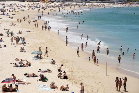 Orang-orang berkumpul di Pantai Bondi saat merayakan Natal di Sydney, Sabtu (25/12/2021). (AP Photo/Rick Rycroft)