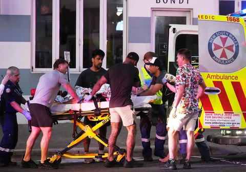 Petugas darurat mengevakuasi warga terluka  setelah dilaporkan terjadi penembakan di Pantai Bondi di Sydney, Minggu, (14/12/2025).