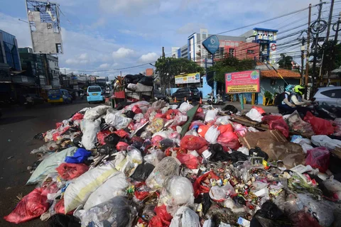 Tumpukan sampah pada median jalan di kawasan Ciputat, Tangerang Selatan, Senin (15/12/2025).
