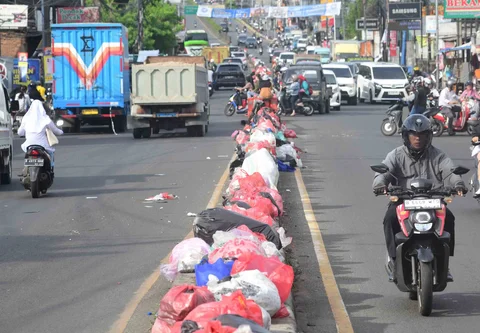 Tumpukan sampah yang dibiarkan begitu saja pada median jalan di kawasan Ciputat, Tangerang selatan, Banten, Senin (15/12/2025).