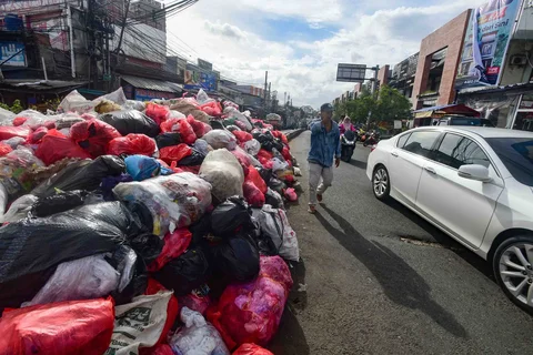 Tumpukan sampah yang dibiarkan begitu saja pada median jalan di kawasan Ciputat, Tangerang selatan, Banten, Senin (15/12/2025).