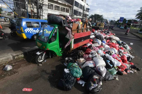Tumpukan sampah yang dibiarkan begitu saja pada median jalan di kawasan Ciputat, Tangerang selatan, Banten, Senin (15/12/2025).