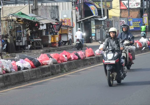Tumpukan sampah yang dibiarkan begitu saja pada median jalan di kawasan Ciputat, Tangerang selatan, Banten, Senin (15/12/2025).